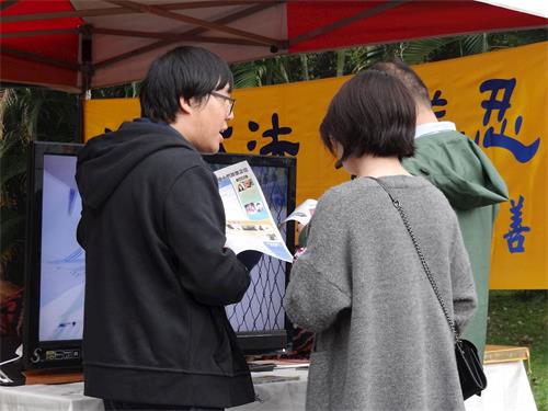 '图2：李威震（左一）正与中国大陆游客讲真相'