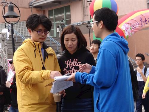 '图4：江山青同学（右一，着蓝色外套）向学生们讲述中共迫害法轮功真相'
