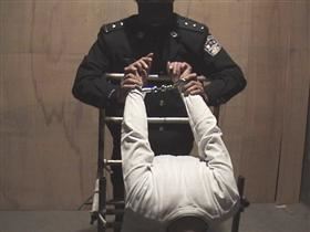 '图2：中共酷刑示意图：双手反背铐在椅子上'