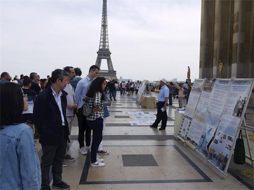'图8：为纪念四二五和平上访二十周年，法轮功学员在巴黎人权广场进行了讲真相的活动。图为游人观看真相展板。'