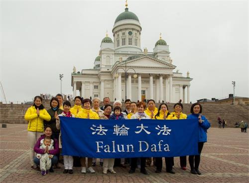 '图1：芬兰法轮功学员在白教堂前恭祝师尊生日快乐。'