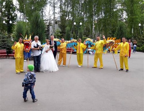 '图2：一对新人与法轮功学员合影留念'