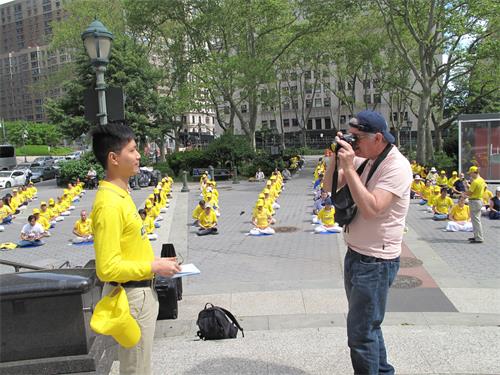 图7：二零一九年五月十八日，从美国宾州匹兹堡来纽约游览的知名摄影师查克·纳齐（Chuck Nacke） 在富利广场遇到正在集体炼功的法轮功学员。