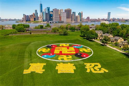 '图1：2019年5月18日，来自全球的部份法轮功学员会聚纽约，在总督岛排出“法轮图形”和“真、善、忍”三字，庆祝世界法轮大法日。'