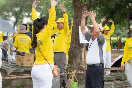 图12～13：2019年5月5日，在高雄桥头糖厂提前庆祝“世界法轮大法日”，很多游客现场学功。