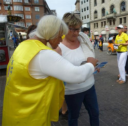 '图10：丹麦法轮功学员、年届80的德裔女士卡伦（Karen）在给路人讲真相。'