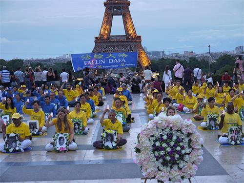 '图1～2：二零一九年七月二十日傍晚，法轮功学员在巴黎人权广场静坐，纪念被中共致死的法轮功同修。'