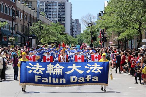 '图1：加拿大国庆游行是蒙特利尔规模最大的游行庆祝活动之一，法轮功学员的游行队伍被观众称赞。'