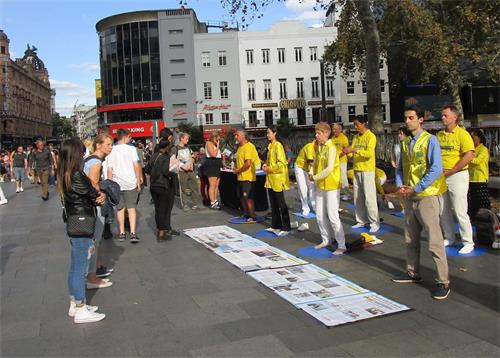 '图12～13：法轮功学员在莱斯特广场举行炼功、讲真相活动。'