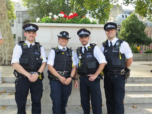 图4：伦敦警察自豪的将法轮功学员赠送的莲花挂在警服上