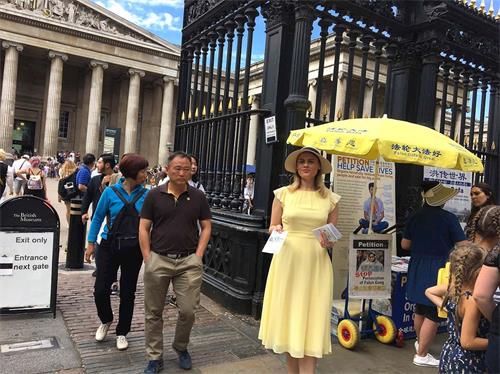 '图3：尤利娅近日在伦敦大英博物馆门外发放法轮大法资料。她还向游人介绍了法轮功学员遭到的迫害。'