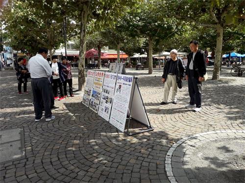 '图5～6：中国游客在保罗广场观看法轮功真相展板'
