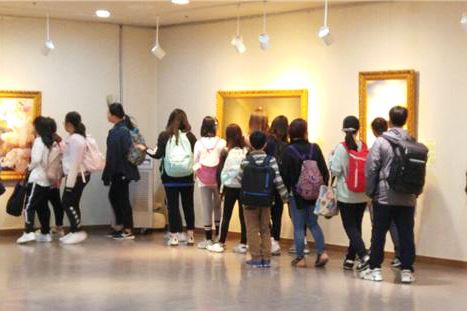 '图5：小学生们在冰上中心展馆的美术展上团体观看'
