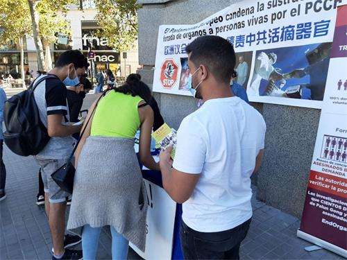 '图1～2：巴塞罗那市中心，民众签名谴责中共迫害法轮功。'
