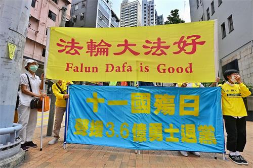 '图1～2：十月一日，香港法轮功学员在中联办门外，举起“法轮大法好”、“天灭中共”等标语。'