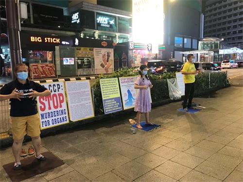 图2：马来西亚法轮功学员在吉隆坡市中心挂展板、炼功，向民众讲真相。