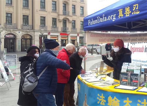 '图1：法轮功学员于二零二零年十二月十九日，在德国慕尼黑市中心卡尔斯广场（Karlsplatz）举办信息日活动。图为慕尼黑民众签名声援法轮功学员反迫害。'