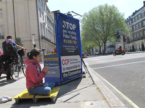 '图3：二零二零年四月二十五日，法轮功学员妮娜（Nina）参加了伦敦中使馆前对面的“四二五”和平请愿。'