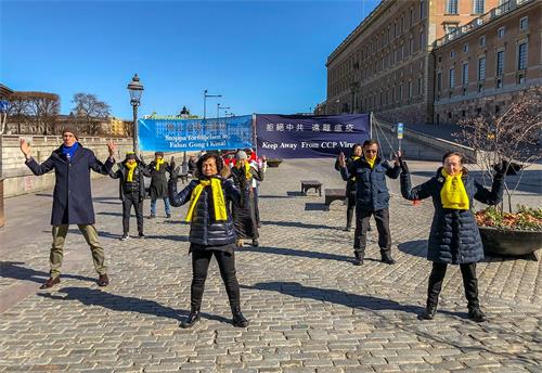 '图3：法轮功学员伴随着炼功音乐向路人演示法轮功的五套功法。'