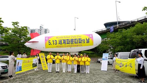 '图1：二零二零年五月十日，为庆祝世界法轮大法日，部份法轮功学员在首尔汉江公园上空放飞舰形飞行器。'