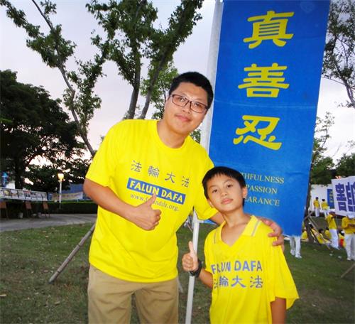 '图14：林岳奇（左）表示，藉由参与活动，让儿子（右）更深入了解法轮功，并珍惜修炼的机会。'