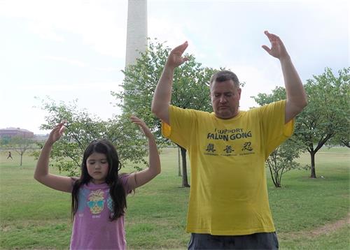 '图10：德裔美国人纽曼（Bjorn Neumann）和女儿在华盛顿纪念碑前炼功。'