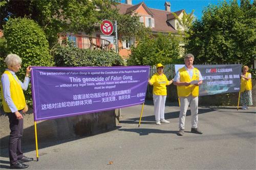 '图1～2：法轮功学员在瑞士中使馆前抗议，要求立即停止迫害。'