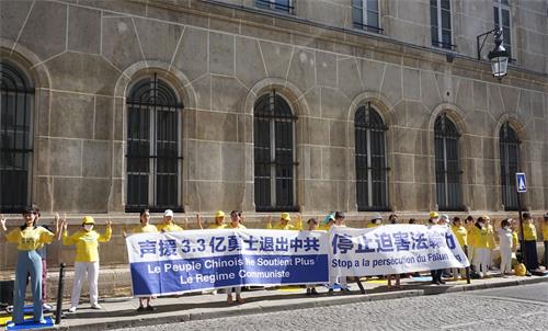 '图1：法轮功学员在巴黎中使馆前举办活动，抗议中共对法轮功长达21年的残酷迫害。'