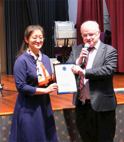 '图4：二零一九年五月三日，悉尼帕拉马塔市（City of Parramatta）市长威尔逊（右）向澳洲法轮<span class='voca' kid='53'>大法</span>学会会长赵博士（Dr Lucy Zhao）颁发了褒奖令，表彰法轮大法为当地社区所作出的贡献，并祝贺法轮大法弘传世界27周年。'