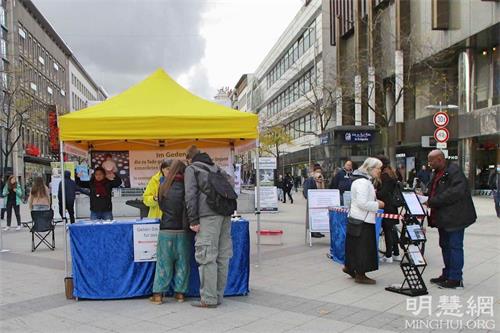 '图1：二零二一年十月十六日，法轮功学员在德国汉诺威（Hannover）中心火车站附近的步行街举办了信息日活动，向当地居民介绍法轮功的<span class='voca' kid='62'>真相</span>。'