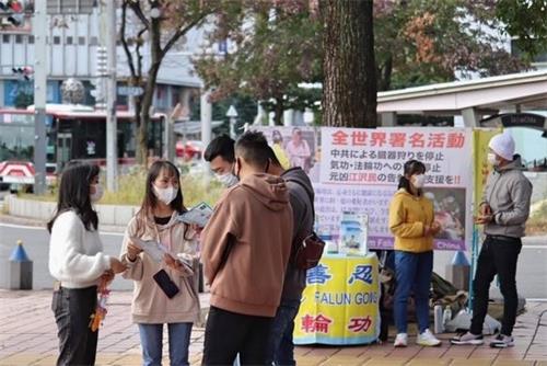 '图4：有不少路人与学员交谈、了解法轮功的真相。'