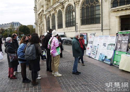 '图7：二零二一年十一月六日，在夏特蕾地铁站外，人们观看法轮功展板，了解真相。'