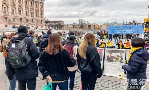 '图1～2：二零二一年十一月份每个周六的下午，法轮功学员都在斯德哥尔摩市中心国会大厦旁的钱币广场举办讲真相活动。'