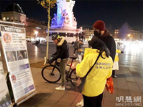 '图2：二零二一年十二月十日，国际人权日当天，在巴黎共和国广场，人们专注看展板，了解法轮功真相。'