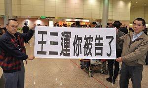 “你被告了”－－中共人权恶棍安徽省长王三运访台，法轮功学员在机场中拉横幅