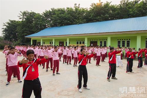 '图7～8：阿尔加利亚职业高中（SEKOLAH?MENENGAH?KEJURUAN?ALJABAR）老师和学生和巴丹岛法轮功学员一同炼功。'