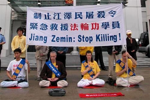 '图2：二零零二年三月十四日，包括四名瑞士人在内的十六名法轮功学员在香港中联办大楼外的街边进行和平请愿。'