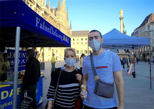 '图4：二零二一年三月三十日在玛琳广场（Marienplatz），伊马姆维奇（Sanad Imamovic）和女友阿科斯巴（Maria Theresa Acosta）签名制止中共强摘法轮功学员器官。'