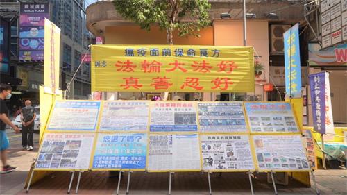 '图1～2：虽然多次遭到中共暴徒袭击，但香港法轮功学员没有退却，真相点一天都没有停止过。图为四月二十三日位于旺角豉油街的法轮功真相点。'