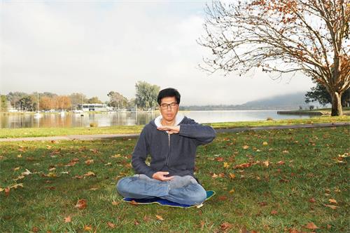 '图3：堪培拉学员李健荣在公园炼法轮功第五套功法——神通加持法。'
