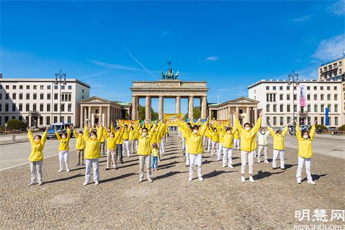 图2～3：二零二一年五月八日，法轮功学员在柏林勃兰登堡门前炼功，恭祝师尊七十岁华诞。