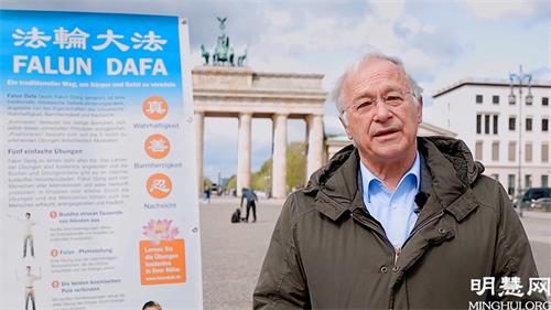 图5：德国国会议员帕策尔特（Martin Patzelt）在柏林勃兰登堡门前，向法轮功学员祝贺世界法轮大法日。