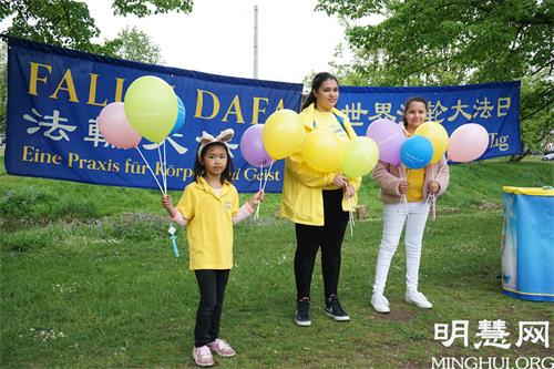 '图3:大法小弟子萨拉(Sara K.,中)和其他孩子一起参加了2021年5月13日在纽伦堡沃德湖畔的法轮大法日庆祝活动。'