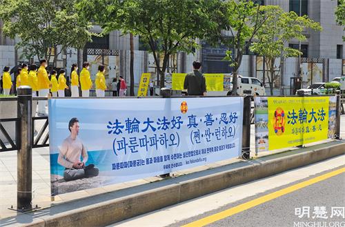 图3：5月13日，部分首尔西部和中部的法轮功学员们在首尔市中心新世界百货店附近举行了集体炼功、派发传单等洪法活动。图为他们在集体炼功的场面。