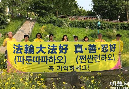 图4：为庆祝法轮大法日，首尔部分学员在瑞草区良才川集体炼功后，恭祝师尊生日快乐！