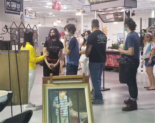 '图2：佛州博览会上，游客们听法轮功学员讲真相。'