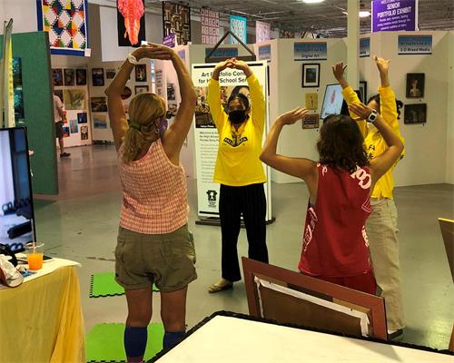 '图3～4：佛州博览会上，游客们现场学炼法轮功。'