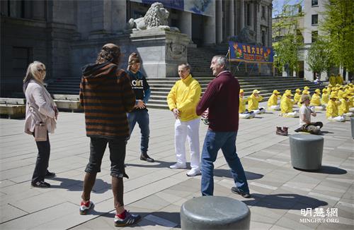 '图5：马克·蒂克纳（Mark Tickner，穿黄衣、白裤者）在现场教人学炼法轮功。'