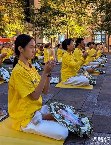 '图1～4：2021年7月18日晚，加拿大魁北克部份法轮功学员在蒙特利尔兵器广场，烛光悼念被中共迫害致死的法轮功学员，呼吁民众的正义和良知，共同制止中共长达22年的反人类罪行。'