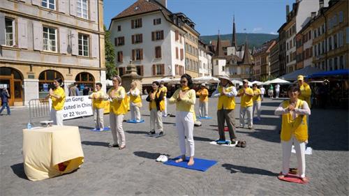 '图1：二零二一年七月二十日，部份瑞士法语区法轮功学员在纳沙泰尔市老城的中心阿勒广场（Place des Halles），举行反迫害二十二周年纪念活动。'